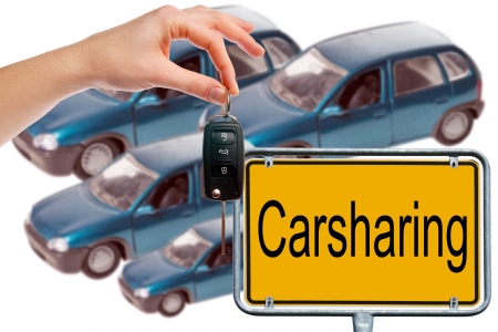 Hand holding car key and Shield with the word Carsharingの写真素材
