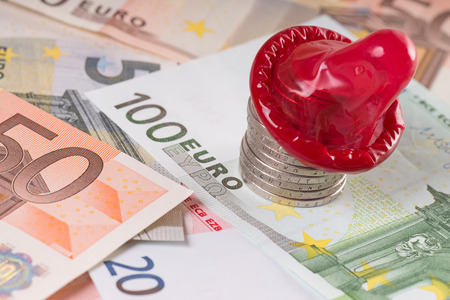 Euro banknotes and Euro coins with condomの写真素材