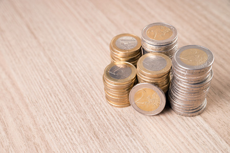 Stack of euro coins on a wooden board