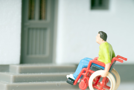 Wheelchair user in front of a houseの写真素材