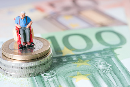 Old man in a wheelchair with moneyの写真素材