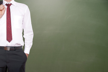 Businessman in front of a blank chalkboardの写真素材