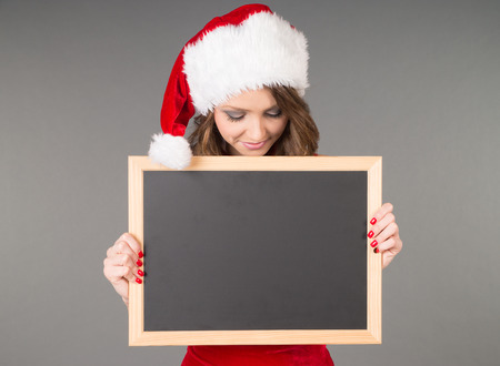 Woman in christmas costume and empty chalkboardの写真素材