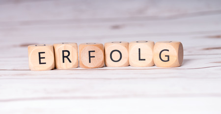 small wooden cubes with the german word Successの写真素材