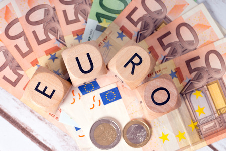 Banknotes and wood dice with the word euroの写真素材