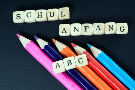 Chalkboard and wood dice with the german words school beginning and ABC