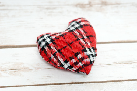 checkered heart on a wooden boardの写真素材