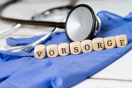 Stethoscope and wood dice with the word precautionの写真素材