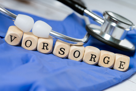 Stethoscope and wood dice with the word precautionの写真素材