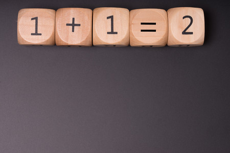 Wooden cube with one plus one equals twoの写真素材
