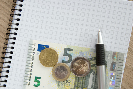 Blank writing pad with a pen and euro moneyの写真素材