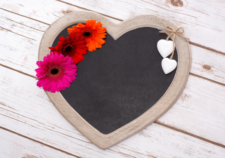 Wooden panel in heart shape with Gerberasの写真素材