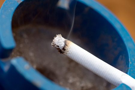 smoldering cigarette in an ashtrayの写真素材