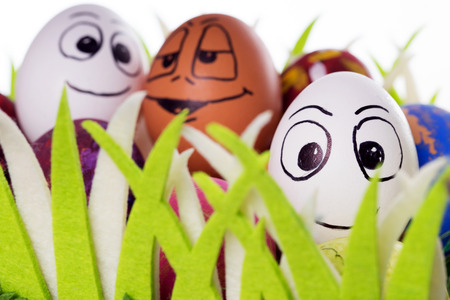 Three funny easter eggs in a easter basketの写真素材