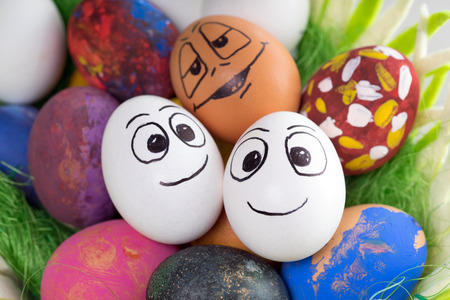 Three funny easter eggs in a easter basketの写真素材