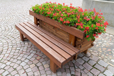 Wooden bench with flower pots and flowersの写真素材