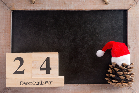 Chalkboard with the date December twenty four and pine coneの写真素材