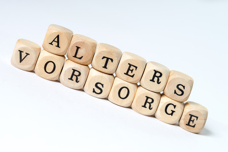 wooden cube with the german words old age provisionの写真素材