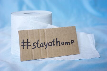 Toilet paper and sign with the words stay at homeの写真素材