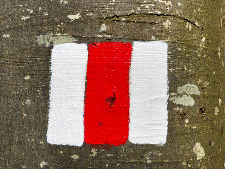 Red and white sign painted on rock marking hiking trail or the Swiss mountain trail markingの写真素材
