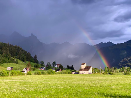 Evening rainbow after the spring downpour over meadows and pastures in the Sihltal valley and by the artifical Lake Sihlsee, Einsiedeln - Canton of Schwyz, Switzerland (Kanton Schwyz, Schweiz)の写真素材