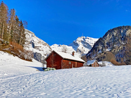 Idyllic Swiss alpine mountain huts and traditional Swiss rural architecture dressed in winter clothes and in a fresh snow cover in the Obertoggenburg region, Unterwasser - Switzerland (Schweiz)の写真素材