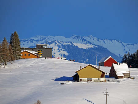 Idyllic Swiss alpine mountain huts and traditional Swiss rural architecture dressed in winter...