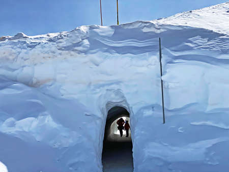 Tunnel dug through deposits of fresh snow above the Glacier du Sex Rouge in the alpine mountain...