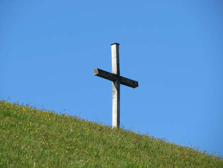 Christian crucifix on the hills and lookouts at the top of the alpine pasture hill Hinderberg...