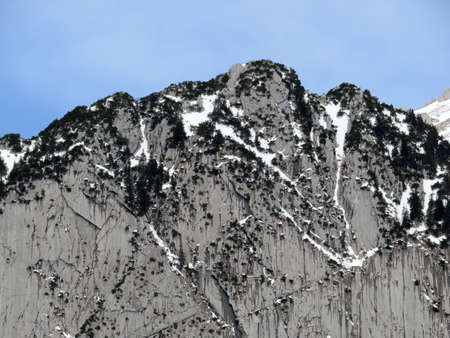 Snow-capped alpine rock Schofbergwand on the south side of the peak Wildhuser Schofberg in Alpstein...