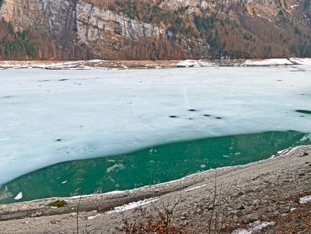 Thawing a frozen lake KlÃ¶ntalersee or Klontaler Lake during early spring in the Alpine valley KlÃ¶ntal (Kloental or Klontal) and in Glarus Alps mountain massif - Canton of Glarus, Switzerland (Schweiz)の写真素材