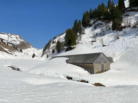 Mountain huts (chalets) or farmhouses and old wooden cattle houses in the alpine valley of KlÃ¶ntal (or Kloental) and by the resevoir lake KlÃ¶ntalersee (Kloentalersee) - Canton of Glarus, Switzerlandのeditorial素材
