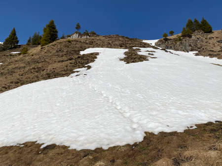 Melting snow cover and early spring ambience in the alpine valleys and icy peaks of the Glarus Alps mountain massif - Canton of Glarus, Switzerland (Schweiz)の写真素材