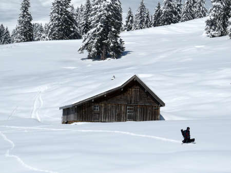 Indigenous alpine huts and wooden cattle stables on Swiss pastures covered with fresh white snow cover, Nesslau - Obertoggenburg, Switzerland (Schweiz)の写真素材