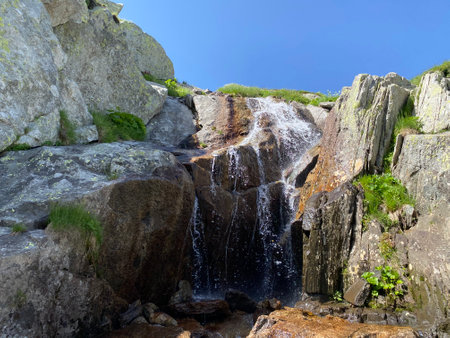 Mountain waterfalls and cascades of alpine streams in the area of the mountain Gotthard Pass (Gotthardpass) in the Swiss Alps, Airolo - Canton of Ticino (Tessin), Switzerlandの写真素材