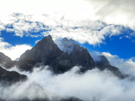 Mystical low autumn clouds and typical mountain fog in Swiss alpine area over the Taminatal river...