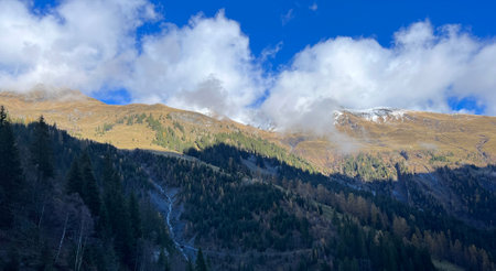 Mystical low autumn clouds and typical mountain fog in Swiss alpine area over the Calfeisental...