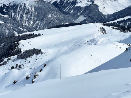 Beautiful sunlit and snow-capped alpine peaks above the Swiss tourist sports-recreational winter resort of Arosa - Canton of Grisons, Switzerland (Schweiz)の写真素材