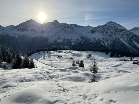 An early frosty morning and the rising sun over the snowy alpine peaks of the famous Swiss winter resort of Arosa - Canton of Grisons, Switzerland (Schweiz)の写真素材