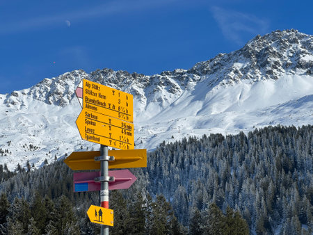 Hiking markings and orientation signs with signposts for navigating in the idyllic winter ambience above the tourist resorts of Valbella and Lenzerheide in the Alps - Switzerlandの写真素材
