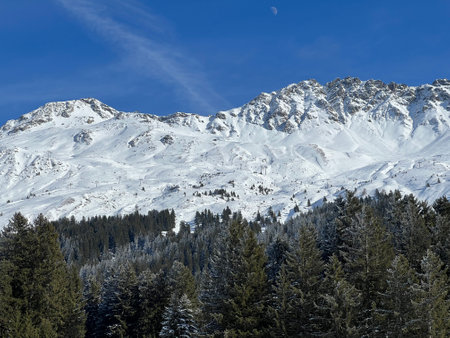 Beautiful sunlit and snow-capped alpine peaks above the Swiss tourist sports-recreational winter resorts of Valbella and Lenzerheide in the Swiss Alps - Switzerland (Schweiz)の写真素材