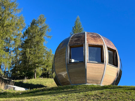 A private accommodation unit in the form of a large wooden ball or a glamping bungalow with a sauna by an alpine lake, Davos Dorf - Canton of Grisons, Switzerland (Schweiz)の写真素材