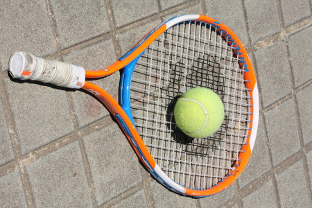abandoned tennis ball and racket on the sidewalkのeditorial素材