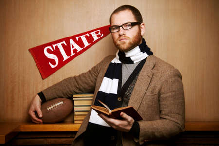 Young man at college with books and footballの写真素材