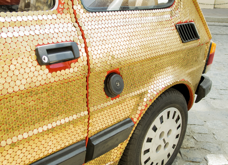 Krakow, Poland-June 10, 2015:
original vintage car with golden coins glued on the coachwork and auto bodyのeditorial素材