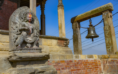 temple in Kirtipur in Kathmandu valley with a hindu divinity statue in the foregroundのeditorial素材