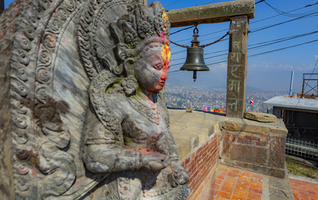 temple in Kirtipur in Kathmandu valley with a hindu divinity statue in the foregroundのeditorial素材