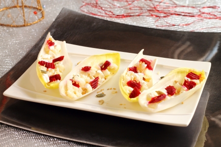 Endives or chicory salad with feta cheese, radishes, oregano and corn on a Christmas tableの写真素材