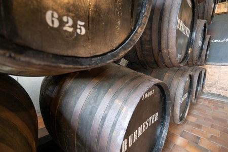 Wine barrels stacked in the cellar of the winery, close-up