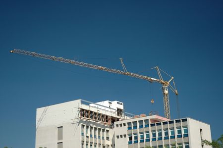 Crane building a new floor on top of a building